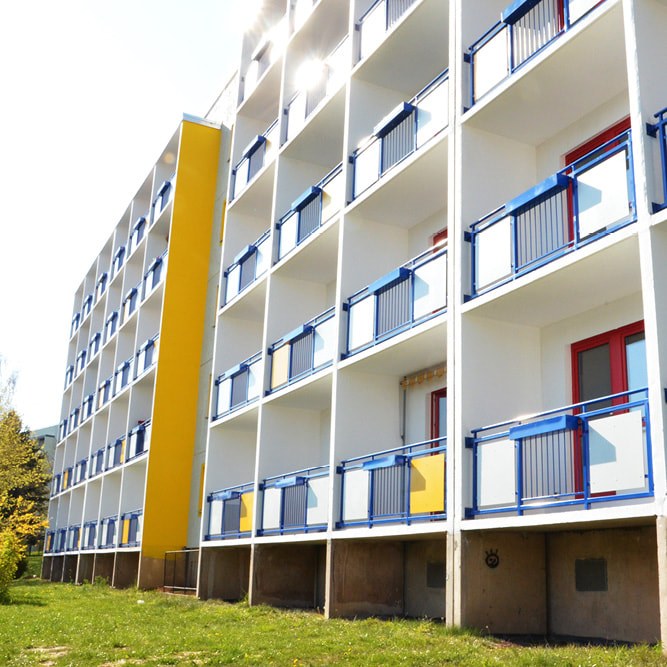 Wohnhaus am Doblinaweg in Döbeln mit blauen Balkonen und gelber Fassadenfläche