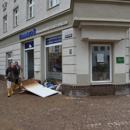 Geschäftsstelle Am Niedermarkt in Döbeln nach dem Hochwasser 2013, davor Sandsäcke und Schlamm