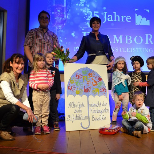 Feier zum 25-jährigen Jubiläum auf der Bühne mit einem gemalten Schirm-Plakat