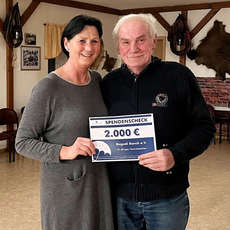 Spendenübergabe: Zwei Personen halten einen Scheck über 2.000 Euro für den Bagadi Ranch e.V. in Seifersdorf