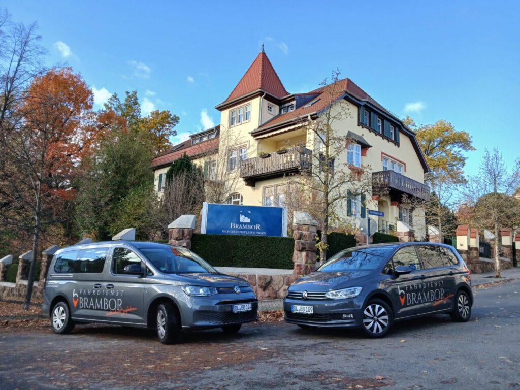 Zwei graue Fahrzeuge mit der Aufschrift „Fahrdienst Brambor“ vor der Villa Brambor in Döbeln