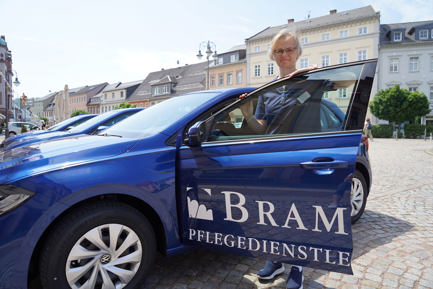 Pflegerin steht an der offenen Tür eines Brambor-Dienstwagens auf dem Marktplatz in Waldheim