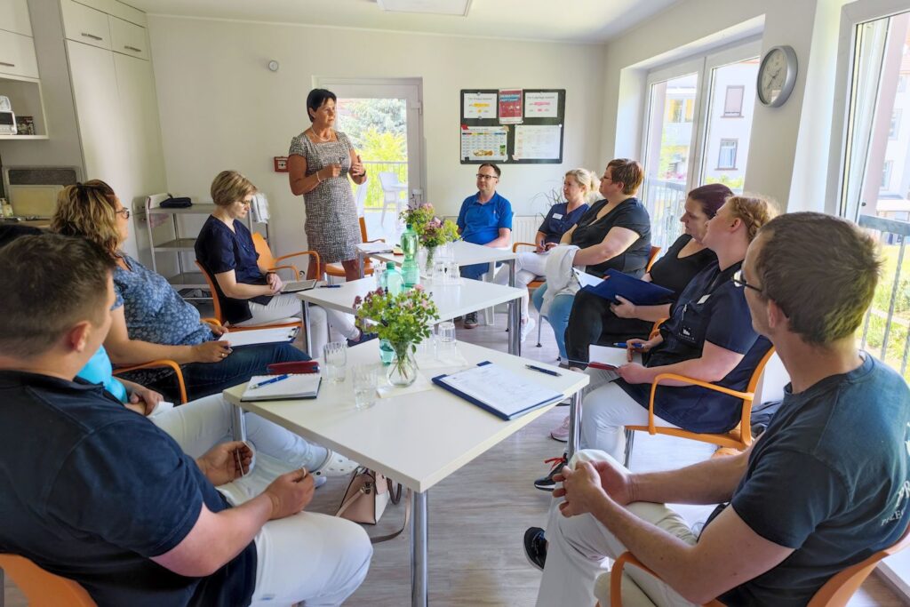 Pflegeteam bei einer Besprechung an einem langen Tisch