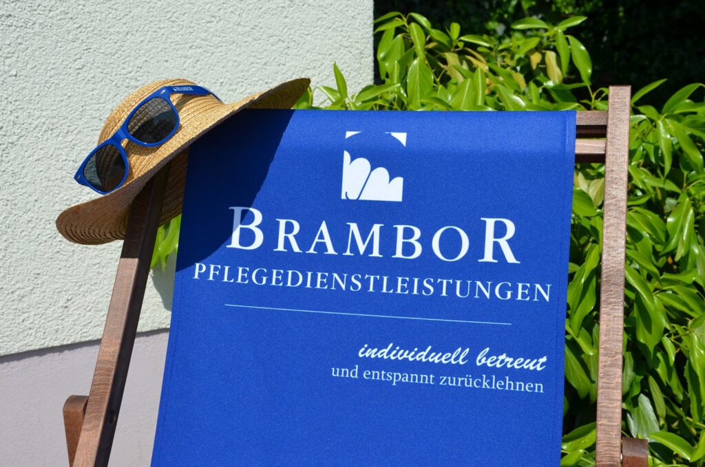 Brambor-Liegestuhl mit Strohhut und dem Spruch „individuell betreut und entspannt zurücklehnen“