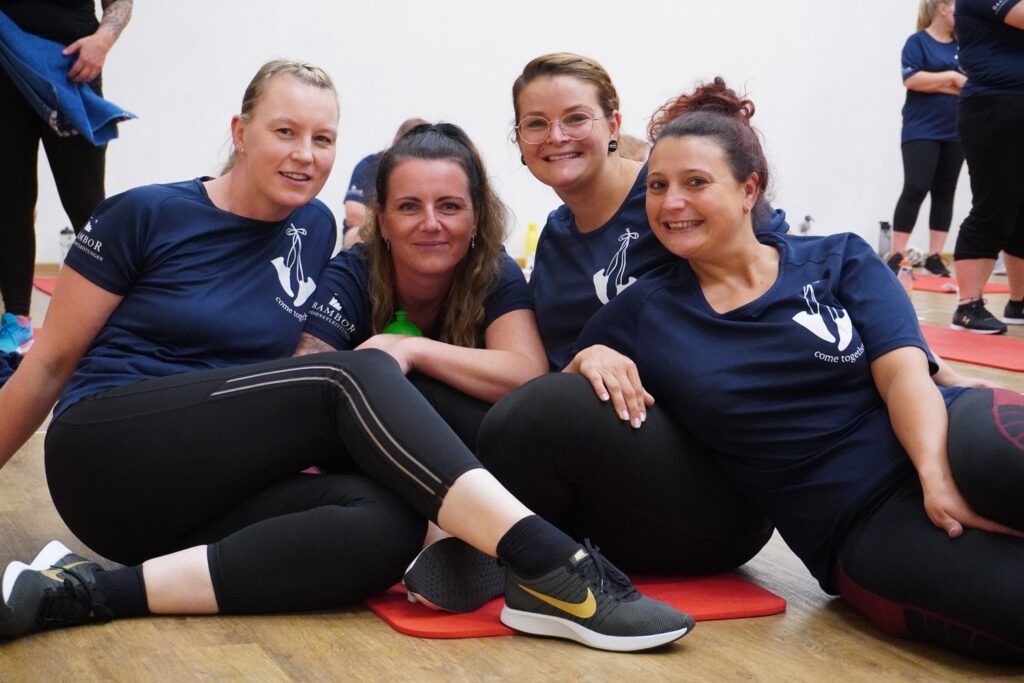 Vier lachende Bramborianerinnen beim Teamsport auf Gymnastikmatten