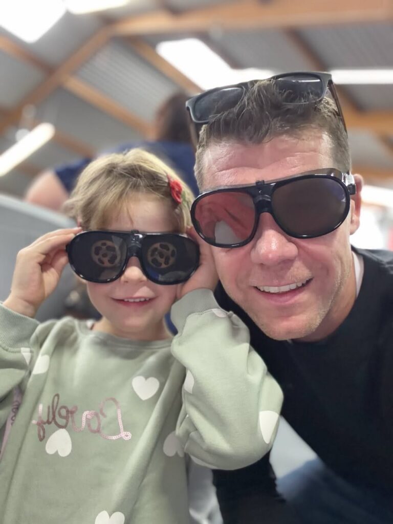 Ein Mann und ein Mädchen machen ein Selfie, beide tragen Simulationsbrillen, die das Sehen einschränken